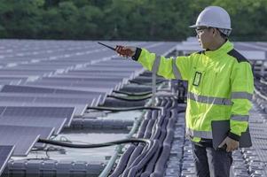 asiatique ingénieur travail à flottant solaire Puissance plante, renouvelable énergie, technicien et investisseur solaire panneaux vérification le panneaux à solaire énergie installation photo