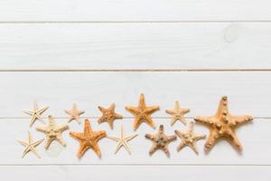 mise à plat de divers coquillages et étoiles de mer sur une table en bois blanc, vue de dessus. copier l'arrière-plan de l'espace, concept d'été photo