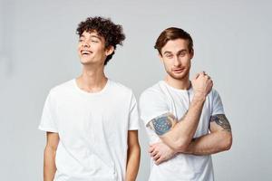 deux de bonne humeur copains dans blanc t-shirts supporter côté par côté tondu vue photo