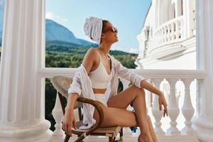 sensuel et magnifique femme serviette et des lunettes de soleil sur balcon paresseux Matin photo