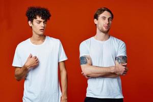 deux Hommes dans blanc t-shirts supporter suivant à la communication rouge Contexte photo