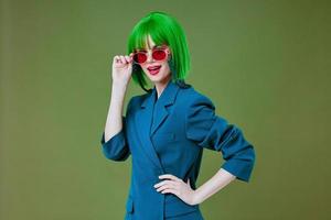 femme dans vert perruque élégant des lunettes mode posant vert Contexte photo