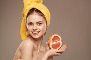 magnifique femme avec une Jaune serviette sur sa tête exotique des fruits agrumes vitamines santé photo