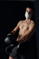 boxeur dans gants et médical masque sur isolé Contexte tondu vue photo