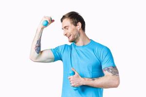 homme avec haltères pompé en haut bras muscles sourire modèle tatouage bleu T-shirt photo