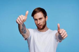 de bonne humeur homme dans blanc T-shirt tatouage sur le sien bras tondu vue mode photo