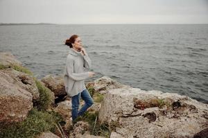 portrait de une femme plage tourisme nuageux temps pierre côte inchangé photo