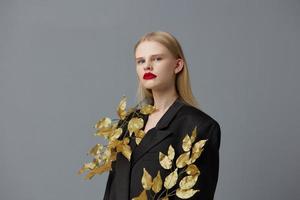 portrait de une femme d'or feuilles noir blazer rouge lèvres studio modèle inchangé photo
