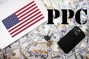 ppc. Payer par Cliquez sur concept. Etats-Unis drapeau, dollar argent avec clés, portable et téléphone Contexte. photo