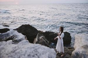 femme dans blanc manteau des pierres la nature temps océan liberté photo