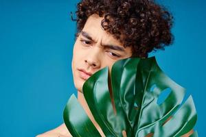 Beau homme avec frisé cheveux nu épaules vert feuille clair peau photo