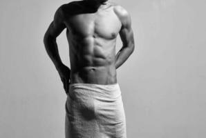 Masculin bodybuilder dans blanc short posant athlète faire des exercices photo