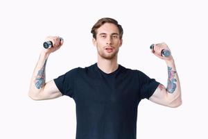 homme avec pompé en haut muscles de bras et haltères noir T-shirt blanc Contexte photo