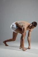 homme Faire des sports à l'intérieur dans blanc short penché vers l'avant côté vue photo