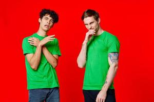 de bonne humeur copains dans vert t-shirts faire des gestes avec mains émotions photo