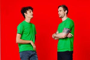 de bonne humeur copains dans vert t-shirts câlins la communication photo