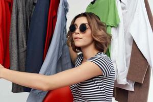 de bonne humeur femme avec des lunettes en essayant sur vêtements magasin vente au détail isolé Contexte photo