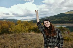 content femme promeneur dans le montagnes sur la nature et une médical masque sur sa main photo