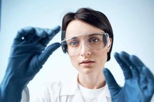 femme avec bleu gants tester recherche une analyse Diagnostique photo