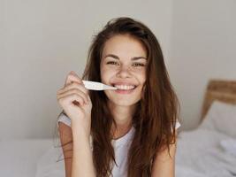 souriant femme en portant thermomètre dans chambre bouche vérification Température photo