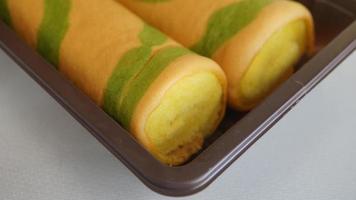 biscuit rouleau éponge gâteau avec vert thé sur blanc Contexte. photo