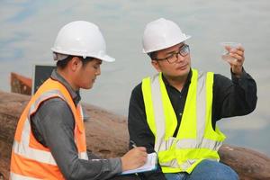 environnement ingénieurs travail à l'eau la source à vérifier pour contaminants dans l'eau sources et en cours d'analyse l'eau tester résultats pour réutiliser.monde environnement journée concept. photo