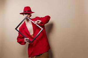 à la mode femme Cadre dans main dans rouge chapeau et veste beige Contexte photo