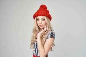 jolie femme dans à la mode vêtements rouge chapeau posant studio photo