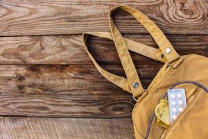 le naissance contrôle pilule et préservatif chutes en dehors de poche avec sacs à main sur en bois Contexte. tonique image. photo