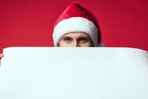 de bonne humeur homme dans une Père Noël chapeau en portant une bannière vacances isolé Contexte photo