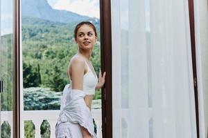 portrait de Jeune magnifique femme dans lingerie sur le balcon magnifique vue de le fenêtre relaxation concept photo