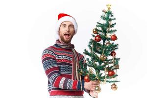 de bonne humeur homme avec une arbre dans le sien mains ornements vacances amusement isolé Contexte photo