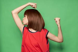 fille baisers le biceps sur sa bras et spectacles le poing à le côté photo