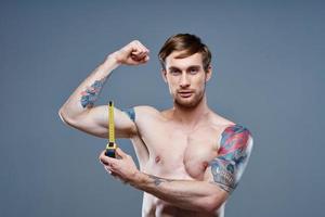 athlète avec gonflé torse bodybuilder aptitude ruban mesure et bras muscles force photo