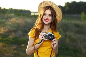 attrayant souriant femme portant chapeau caméra la nature loisir photo