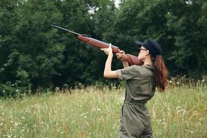 militaire femme en portant une pistolet en haut chasse vert sac à dos photo