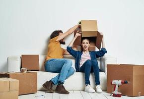 homme et femme asseoir sur blanc canapé des boites avec en mouvement mode de vie des choses photo