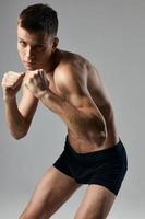 boxeur sur une gris Contexte nu torse bodybuilder aptitude photo