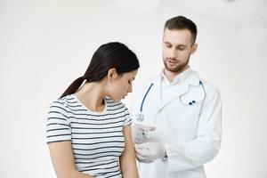 Masculin médecin donnant un injection à une patient dans une hôpital vaccination photo