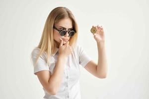 de bonne humeur femme des lunettes de soleil bitcoin crypto-monnaie dans mains lumière Contexte photo
