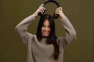 portrait femme dans une chandail écoute à la musique avec écouteurs amusement vert Contexte photo