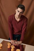 agréable homme dans une rouge chemise avec des oranges sur le studio miroir photo