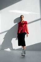femme dans à la mode l'automne des chaussures rouge veste et noir pantalon sur une lumière Contexte photo