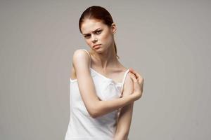 femme dans blanc T-shirt rhumatisme douleur dans le cou santé problèmes lumière Contexte photo