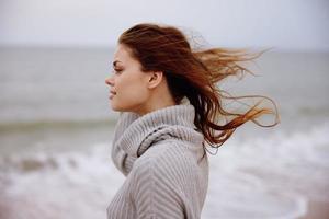 portrait de une femme seul par le océan nuageux temps mode de vie photo