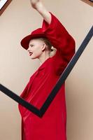 femme Cadre dans main dans rouge chapeau et veste studio modèle inchangé photo