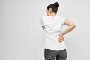 femme dans blanc T-shirt santé problèmes retour douleur photo