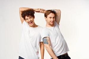 deux marrant copains dans blanc t-shirts en riant positif émotions photo