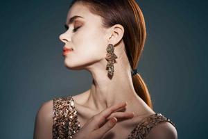 femme dans or robe et des boucles d'oreilles bijoux charme modèle photo