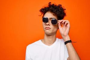 frisé gars portant des lunettes de soleil mode jeunesse style Orange Contexte photo